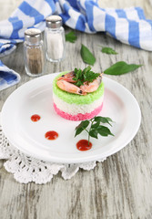Colored rice on plate near napkin on  wooden table