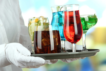 Waitresses holding tray with glasses of cocktails