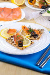Salmon sandwiches on plate  on wooden table close-up