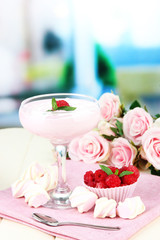 Raspberry milk dessert in cocktail glass, on bright background
