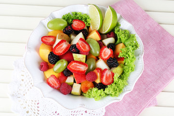 Fruit salad in plate on napkin  wooden table