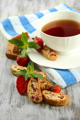 Cup of tea with cookies and strawberries on table close-up