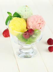 Tasty ice cream scoops, on wooden table