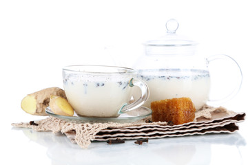 Teapot and cup of tea with milk and spices