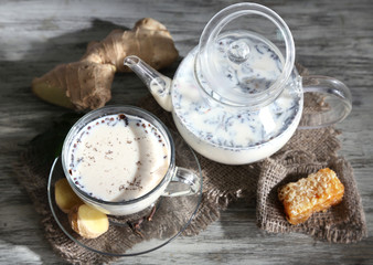 Teapot and cup of tea with milk and spices