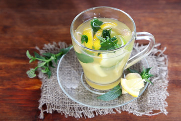 Cup of tea with ginger on sackcloth on wooden table