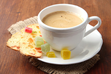 Cup of tasty coffee with Italian biscuit, on wooden background