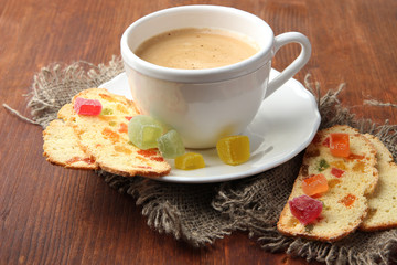 Cup of tasty coffee with Italian biscuit, on wooden background