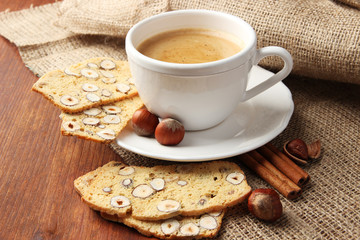 Cup of tasty coffee with Italian biscuit, on wooden background