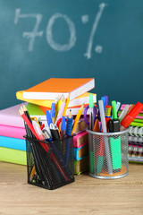 Office supplies on table on school board background