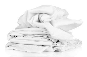 Stack of rumpled bedding sheets isolated on white
