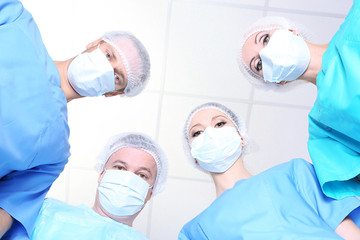 View from below of surgeons in protective work wear during
