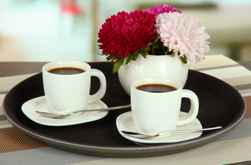 Cups of coffee on tray on table in cafe