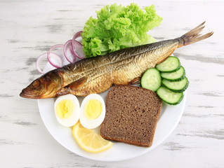 Smoked fish on plate on wooden table