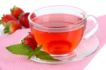 Delicious strawberry tea on table on white background