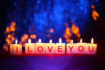 Candles with printed sign I LOVE YOU,on  blur lights background