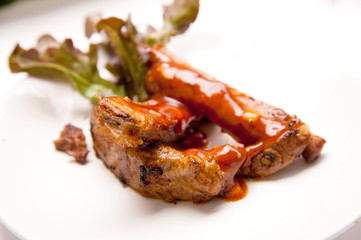 Pork ribs steak with vegetable on white dish