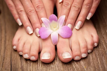Keuken spatwand met foto Relaxing pink manicure and pedicure with a orchid flower © marinasvetlova