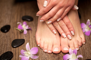Relaxing pink manicure and pedicure with a orchid flower - obrazy, fototapety, plakaty
