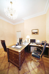 Workplace with computer and soft armchair in home office