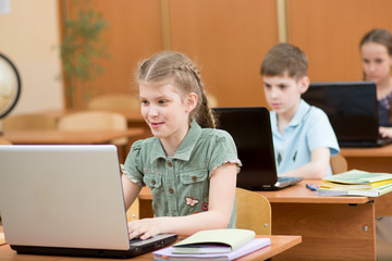 school kids using laptop at lesson