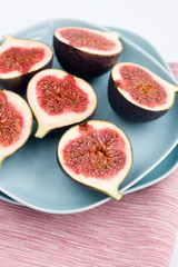Ripe figs lying on a blue plate on a pink napkin