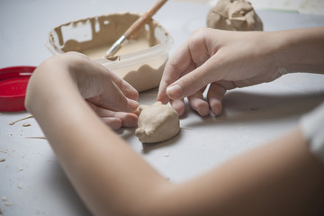 Girl make toyfrom clay