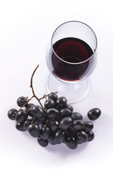 Red wine and a string of grapes on white background
