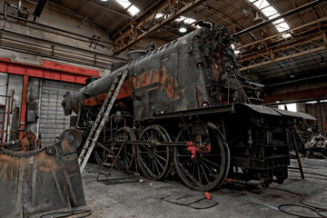 Fototapeta na wymiar Old industrial locomotive in the garage