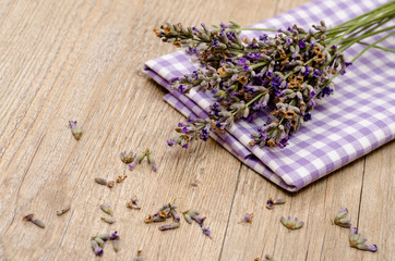 Lavendelblüten auf einem Tuch und Holz