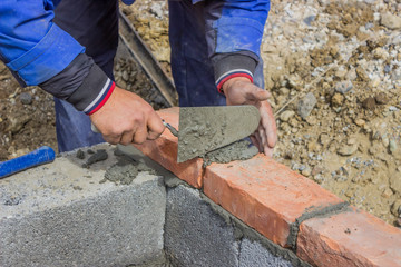 Man laying concrete block and bricks wall 2