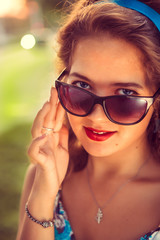 Naklejka premium American redhead girl in suglasses. Photo in 60s style.