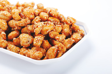 crispy peanut with sesame in plate on white background