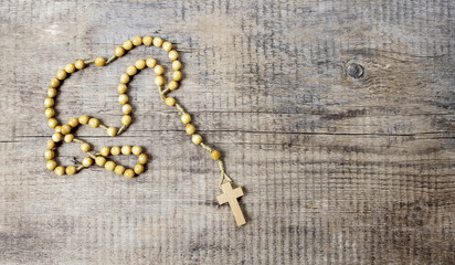 Fototapeta na wymiar Rosary on wooden table. Copy space
