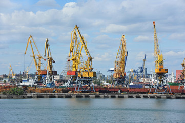 Port cargo crane over blue sky background