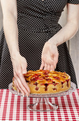 Obraz na płótnie Canvas Woman holding strawberry pie on cake stand. Party table, selecti