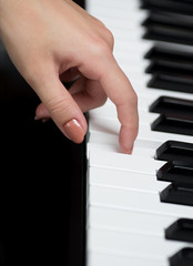 A hand of a girl playing piano. Selective focus.