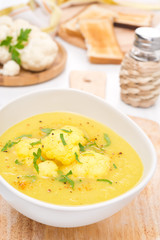 cauliflower soup with curry in a white bowl