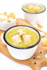 zucchini soup with croutons on a wooden board, close-up