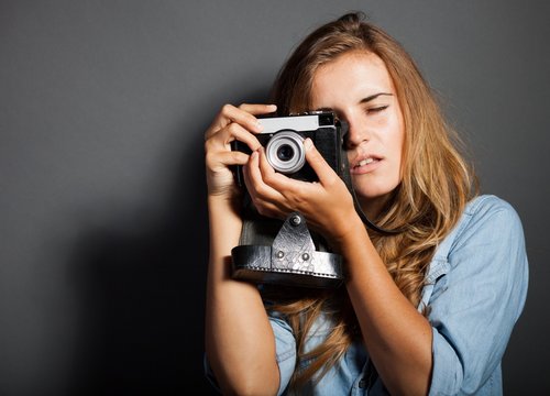 Photographer woman holding old camera, taking pictures