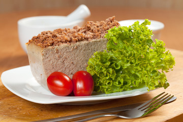 Venison pate on a plate decorated with salad.