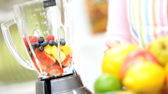 Young Female Using Blender Organic Fruit Drink
