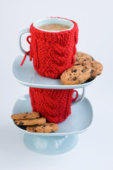 Two blue cups in knitted covers and chocolate cookies
