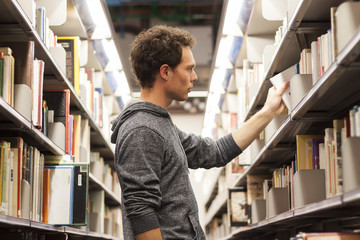 Student selecting a book in a library