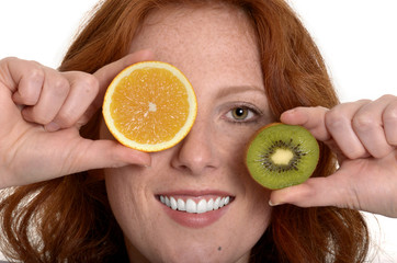 Hübsche rothaarige Frau mit Obstscheiben lächelt