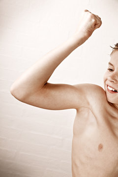 Side profile of a boy flexing bicep