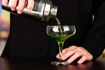 Bartender making cocktail on bright background, close-up