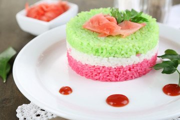 Colored rice on plate on napkins on wooden table