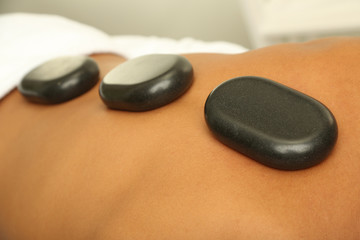 Fototapeta na wymiar Gorące kamienie na plecach przed masażem bliska