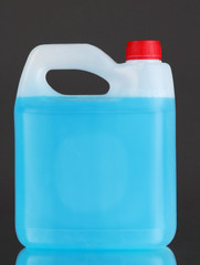Blue liquid for car in canister on grey background